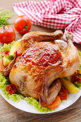 Delicious baked chicken on plate on table close-up