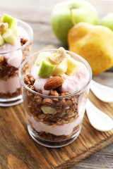 Healthy layered dessert with muesli and berries on table