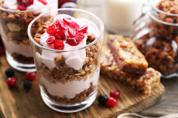 Healthy layered dessert with muesli and berries on table