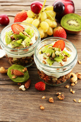 Healthy layered dessert with muesli and fruits on table