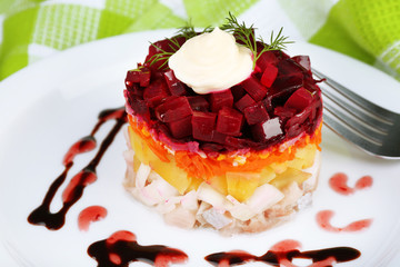 Russian herring salad on plate on wooden table background