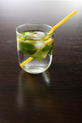 Summer cocktail with ice cubes on wooden table