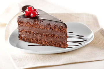 Delicious chocolate cake on plate on table on light background
