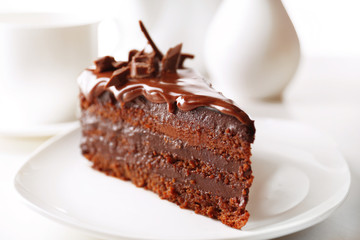 Delicious chocolate cake on plate on table on light background