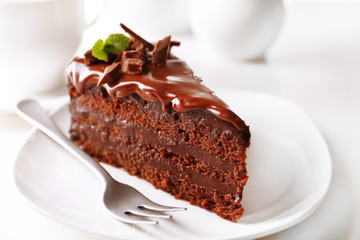 Delicious chocolate cake on plate on table on light background