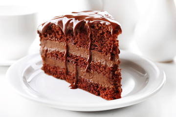 Delicious chocolate cake on plate on table on light background