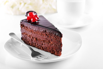 Delicious chocolate cake on plate on table on light background
