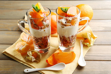 Healthy layered dessert with muesli and fruits on table