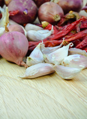 garlic cloves , shallot ,dry chili pepper  on wood cutting boar
