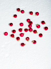 Red ornaments on white snow