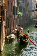 Fototapeta na wymiar Lone gondolier in Venice Floating