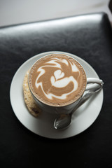 Hot coffee  with latte art on black table