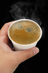 Hand holding coffee cup,isolated on black