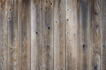 Vetical worn fence boards with gray finish with knots