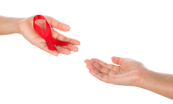 AIDS ribbon in hand isolated on white background