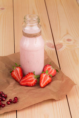 Strawberry milkshake on a wooden background.