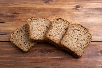 Sliced loaf of rye bread on rustic wooden background
