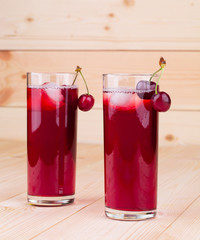 Cherry smoothie on the wooden background.
