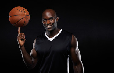 Confident basketball player balancing ball on finger