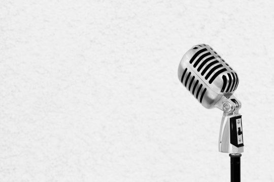 Silver vintage microphone in the studio on white wall background