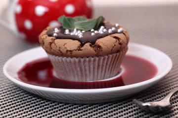 Chocolate cupcake muffin  with a strawberry syrup or wine