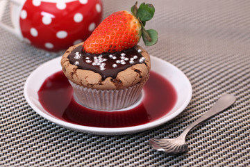 Chocolate cupcake muffin with a strawberry syrup or wine