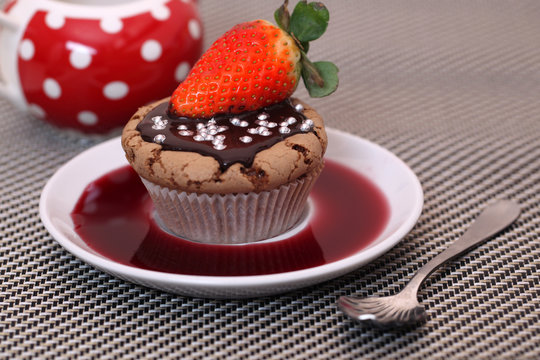Chocolate cupcake muffin with a strawberry syrup or wine