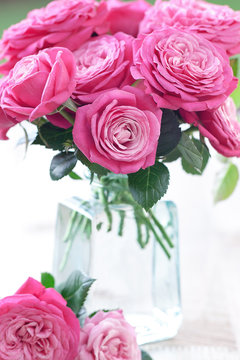 Beautiful fresh pink roses in a vase on a table.