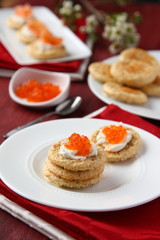 Oat bran cookies with red caviar and cream cheese