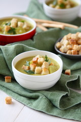 Creamy sweet potato soup with croutons and parsley in white bowl