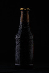 Cold bottle of beer on black background