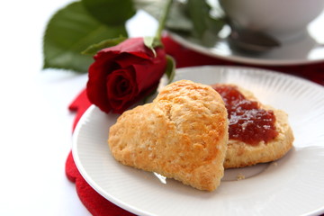 Heart shaped scones with strawberry jam and a cup of tea