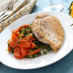 Roast chicken breast with vegetables on white plate