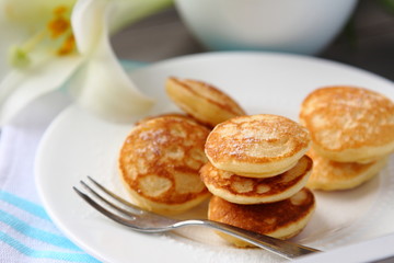 Fototapeta na wymiar Dutch mini pancakes called poffertjes