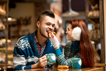 Young couple with coffee at the cafe in winter