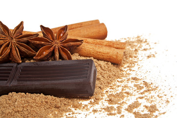 Cinnamon sticks, chocolate and anise on a white background