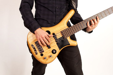 Close up of a brown bass guitar with hands