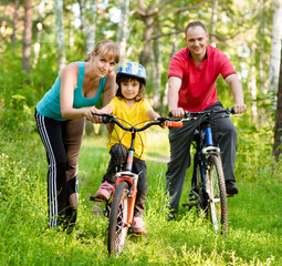 Obraz premium mother teaches his daughter to ride a bike