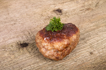 cutlet with parsley leaves on old wooden table