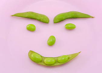 Green soybeans in pink dish isolate on white background