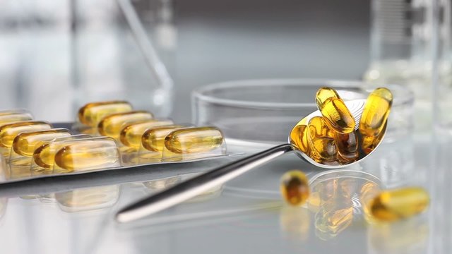 vitamins supplements pills omega 3 in spoon panning