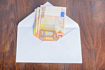 Open envelope with euro banknotes on table