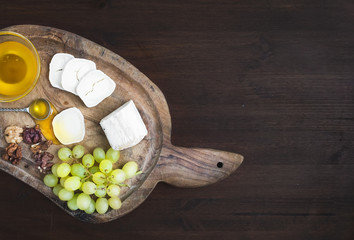 Goat brie cheese with fresh greapes, walnuts and honey on a rust