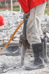 worker using construction drilling cement on the ground