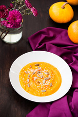 Pumpkin cream-soup with seeds in a plate