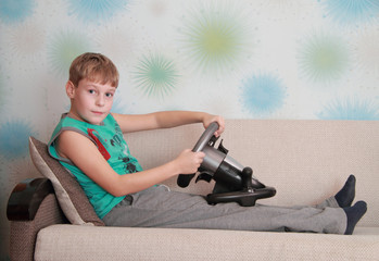 child on couch with computer-game device