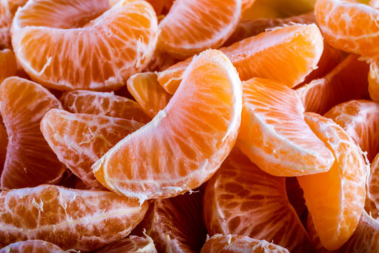 Tangerine or mandarin orange segments peeled close up background