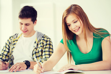 Fototapeta premium smiling students with textbooks at school