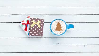 Fototapeta na wymiar Gift box and cappuccino on white wooden table.