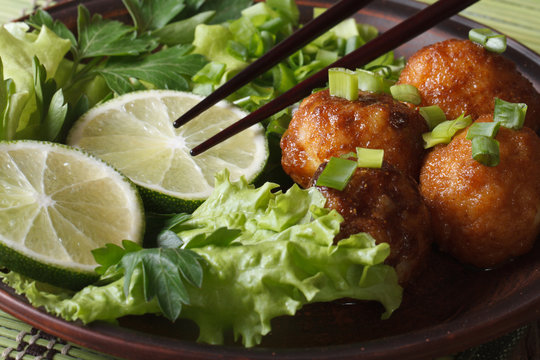 fish balls with lime and salad and chopsticks macro. Horizontal